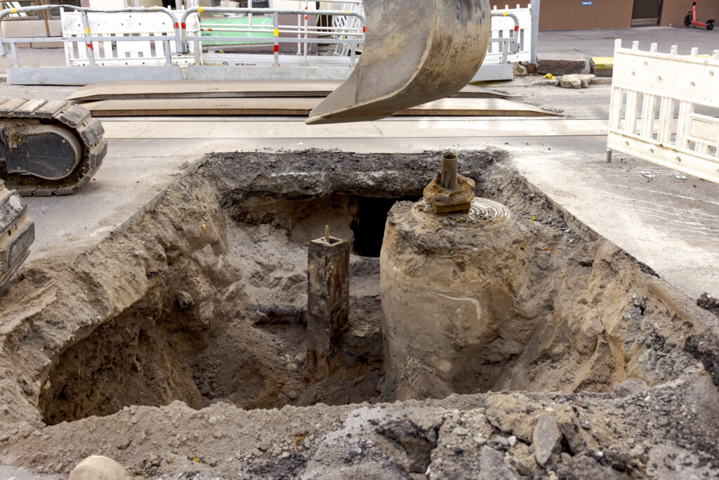 Katutyömaa, jossa kaivinkone kaivaa asfalttia auki.